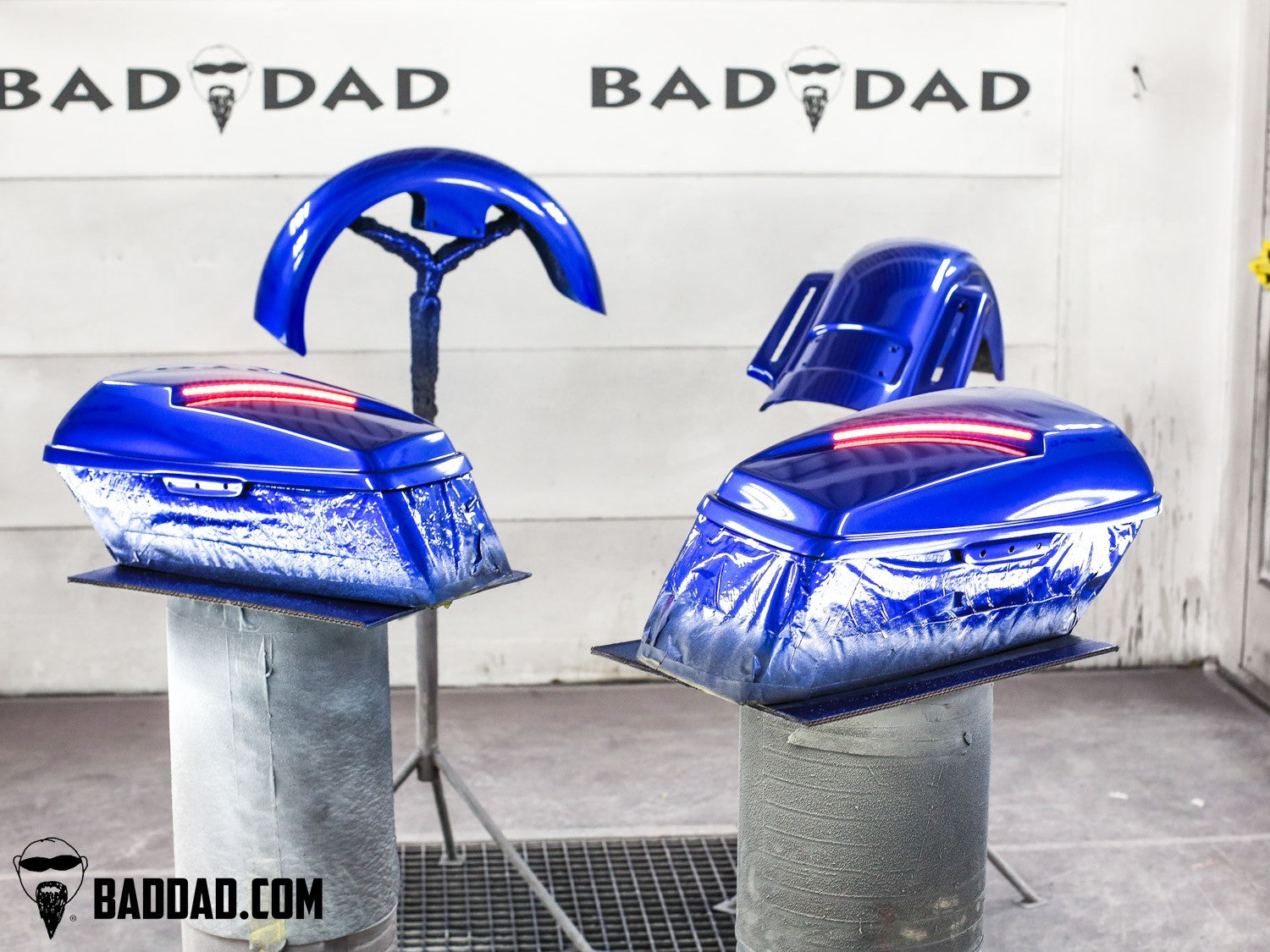 Blue custom saddlebag lids and fenders freshly painted for a Road King