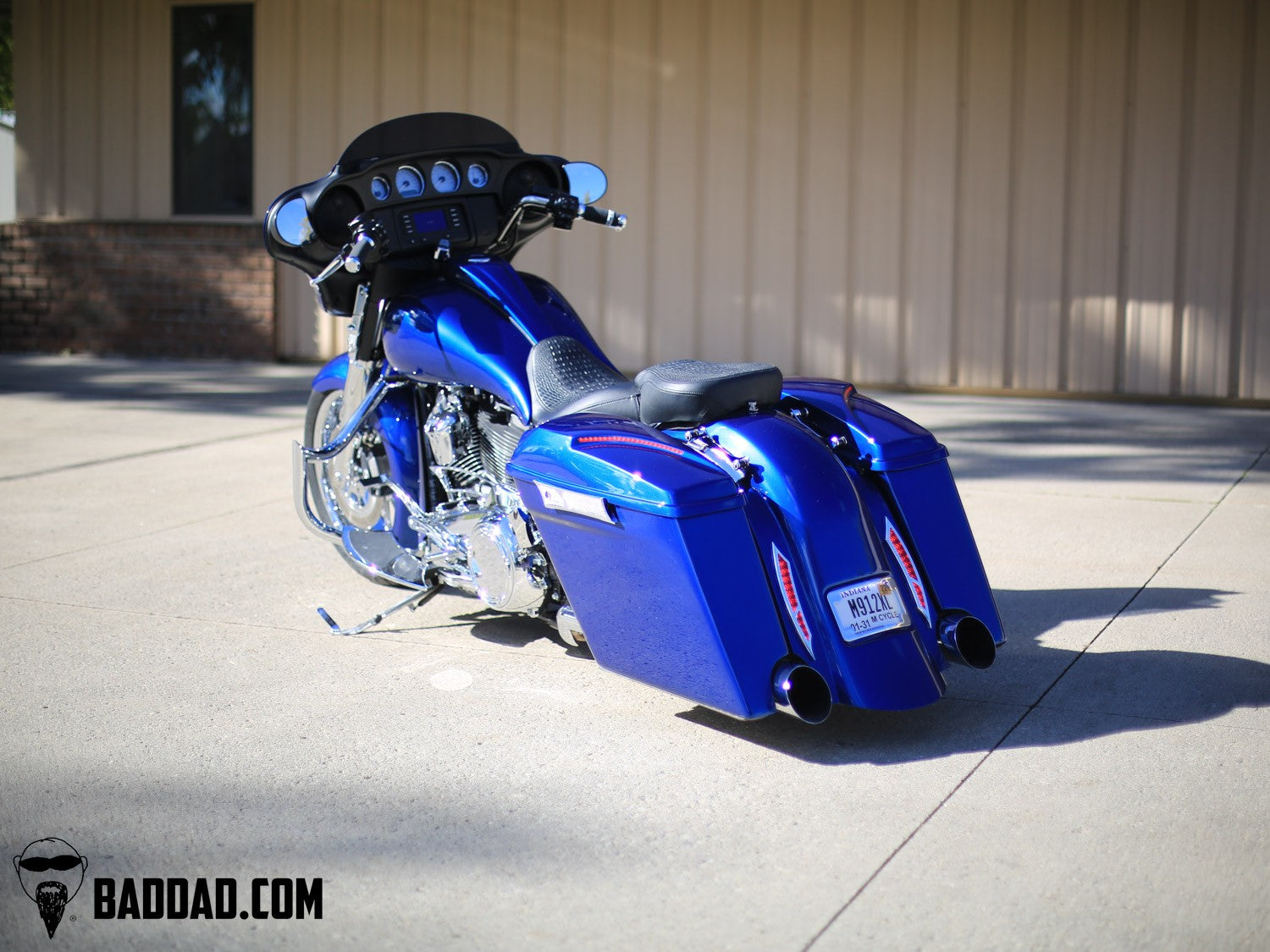 Blue custom saddlebag lid set on a Street Glide bagger, rear three-quarter view
