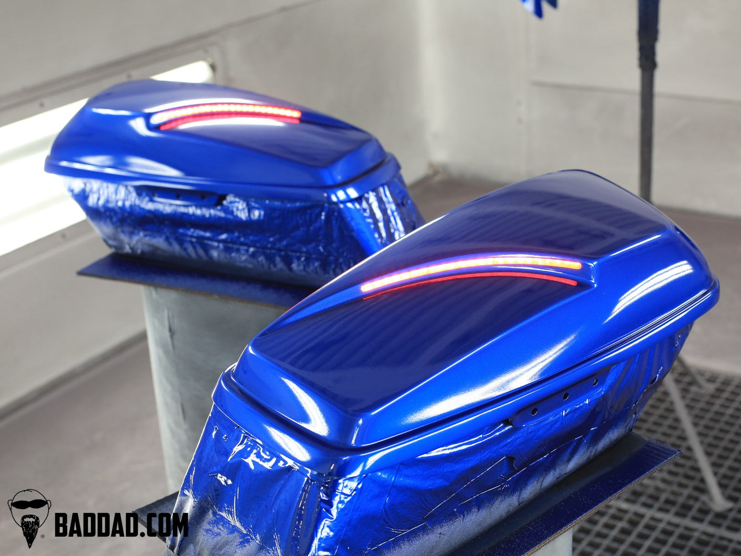 Blue custom saddlebag lids curing in the paint booth before Street Glide install