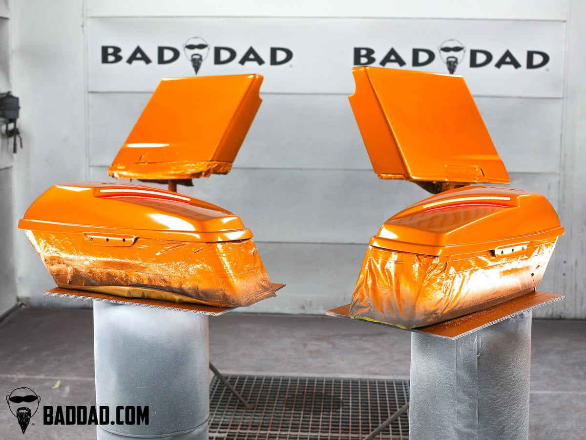 Orange custom saddlebag lids with LED taillights curing in the paint booth