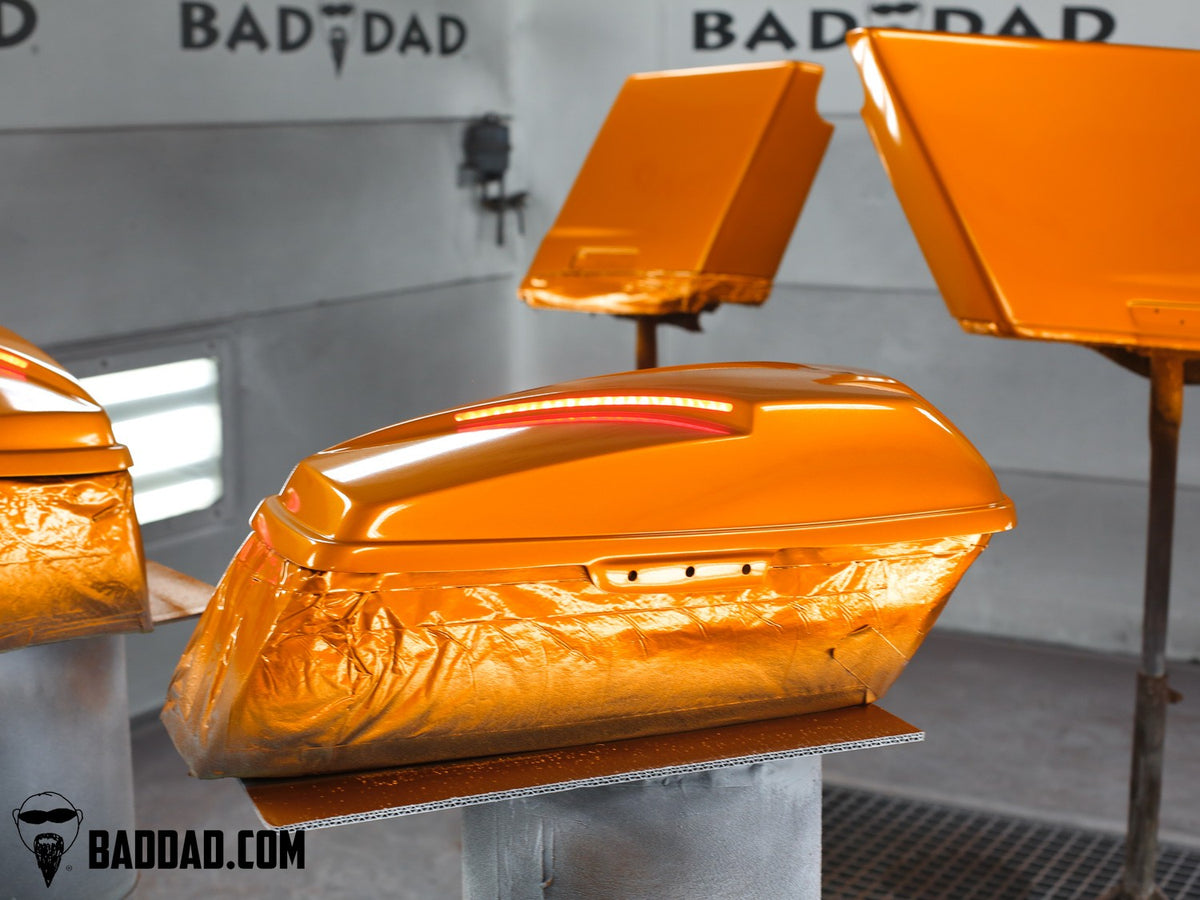Pair of orange saddlebag lids with LED taillights, custom paint finish